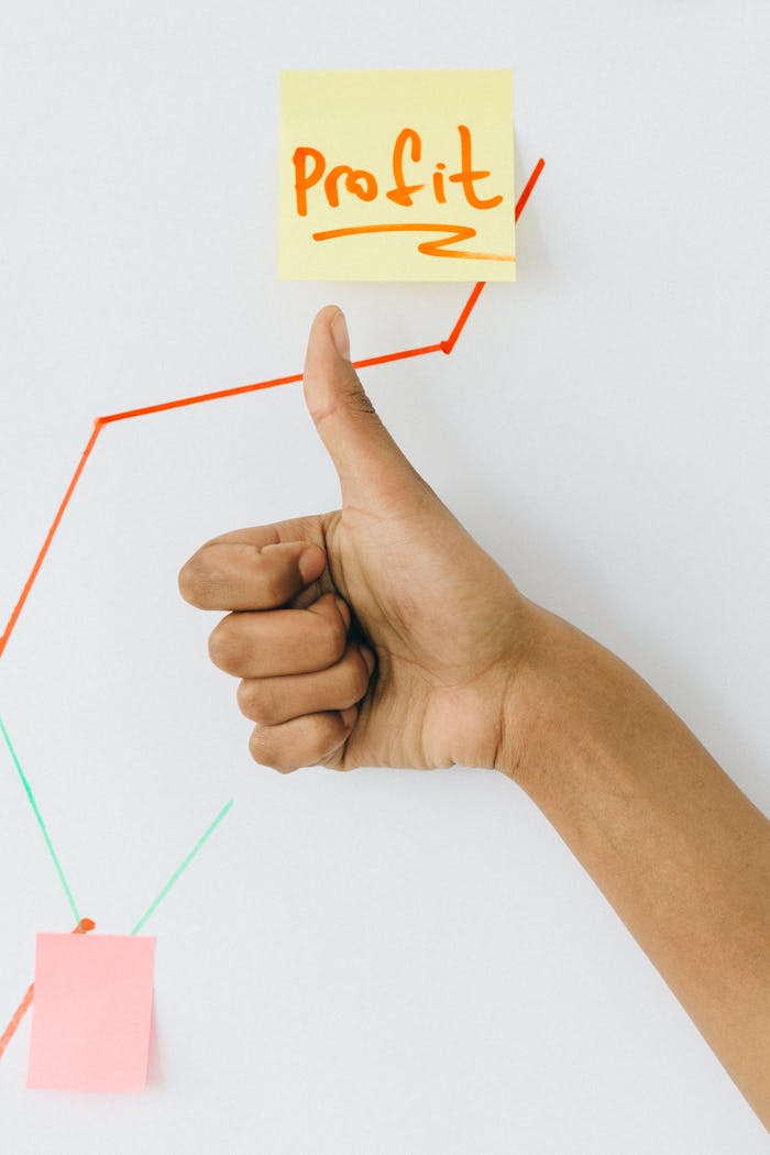 about-02 A hand giving a thumbs up in front of a profit growth chart, highlighting success.